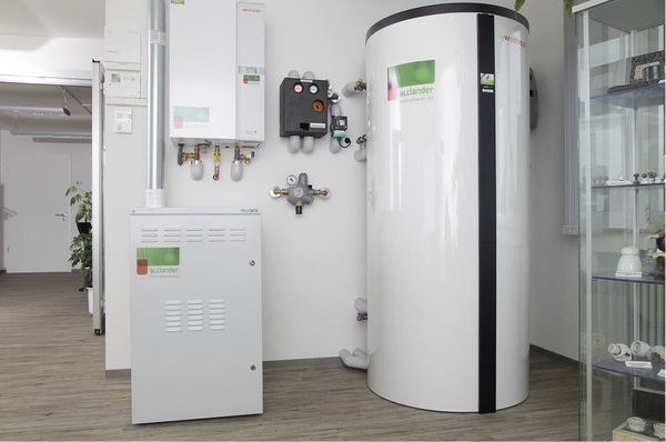 Abb. 1 Die im Juni 2010 installierte BlueGen-Brennstoffzelle (links unten) mit wandhängendem Gas-Brennwertheizkessel zur Abdeckung von thermischen Lastspitzen arbeitet auf einen Pufferspeicher, um den kontinuierlichen Wärmestrom der Brennstoffzelle bei tatsächlichem Bedarf nutzen zu können.