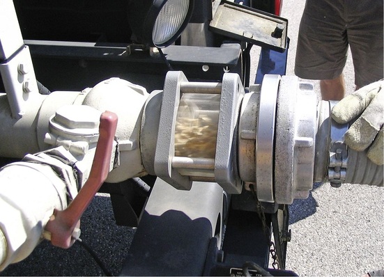 Abb. 1 Holzpellets auf dem Weg ins Brennstofflager: Mittels auf die örtlichen Gegebenheiten abgestimmtem Druck in der Kesselkammer des Lieferfahrzeugs und dem Treibluftvolumenstrom wird der Brennstoff über einen bis zu 30 m langen Füllschlauch transportiert. Der Einblasvorgang dauert etwa vier Minuten pro Tonne.