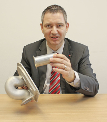 Abb. 1 Burkhard Maier zu dem Brötje-intern als „Elefantenrüssel“ bezeichneten Mischkanal der neuen Gas-Brennwertheizkessel: „Es gehört schon ein wenig Mut dazu, ein so verschnörkeltes Bauteil in einem modernen Heizkessel einzubauen. Ich kann aber versichern, die ungewöhnliche Geometrie ist pure Absicht und wirkt sich über den nach unten ausgeweiteten Modulationsbereich positiv auf den Anlagenwirkungsgrad aus.“