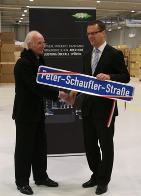 Stephan Neher (rechts), Oberbürgermeister der Stadt Rottenburg am Neckar, übergibt das Straßenschild an Peter Schaufler.
