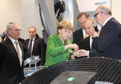 Rainer Hundsdörfer (rechts), Vorsitzender der Geschäftsführung der ebm-papst Gruppe, begrüßte gemeinsam mit Firmengründer Gerhard Sturm (links) Angela Merkel und Wladimir Putin am ebm-papst Messestand. (Quelle: ebm-papst)
